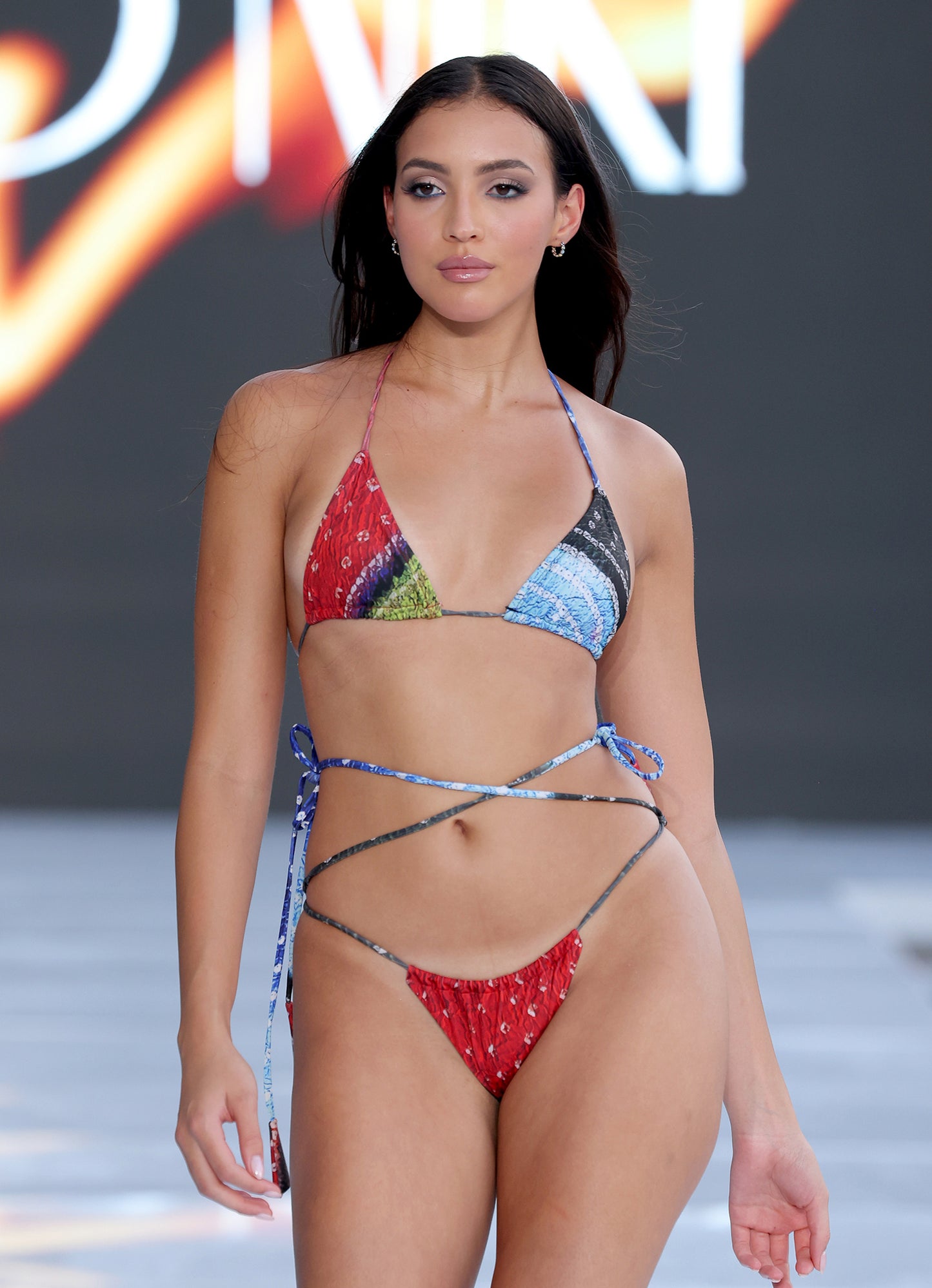 Lifestyle photo of Earth Triangle Bikini Top in blue and red – can be styled four different ways